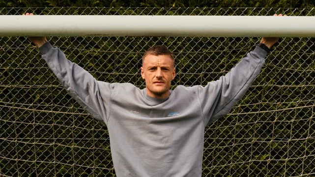 Jamie Vardy stood in a goal with his arms outstretched and holding onto the crossbar